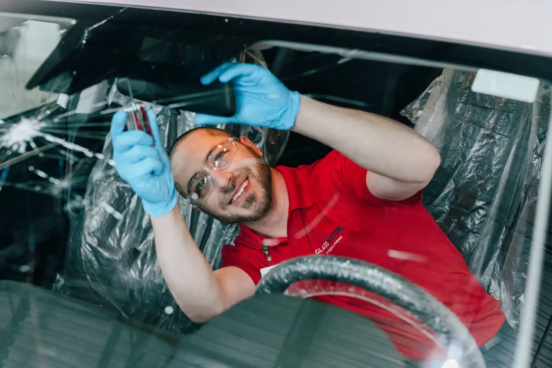 Glass Doctor auto glass technician performing auto glass repair services on a car windshield.