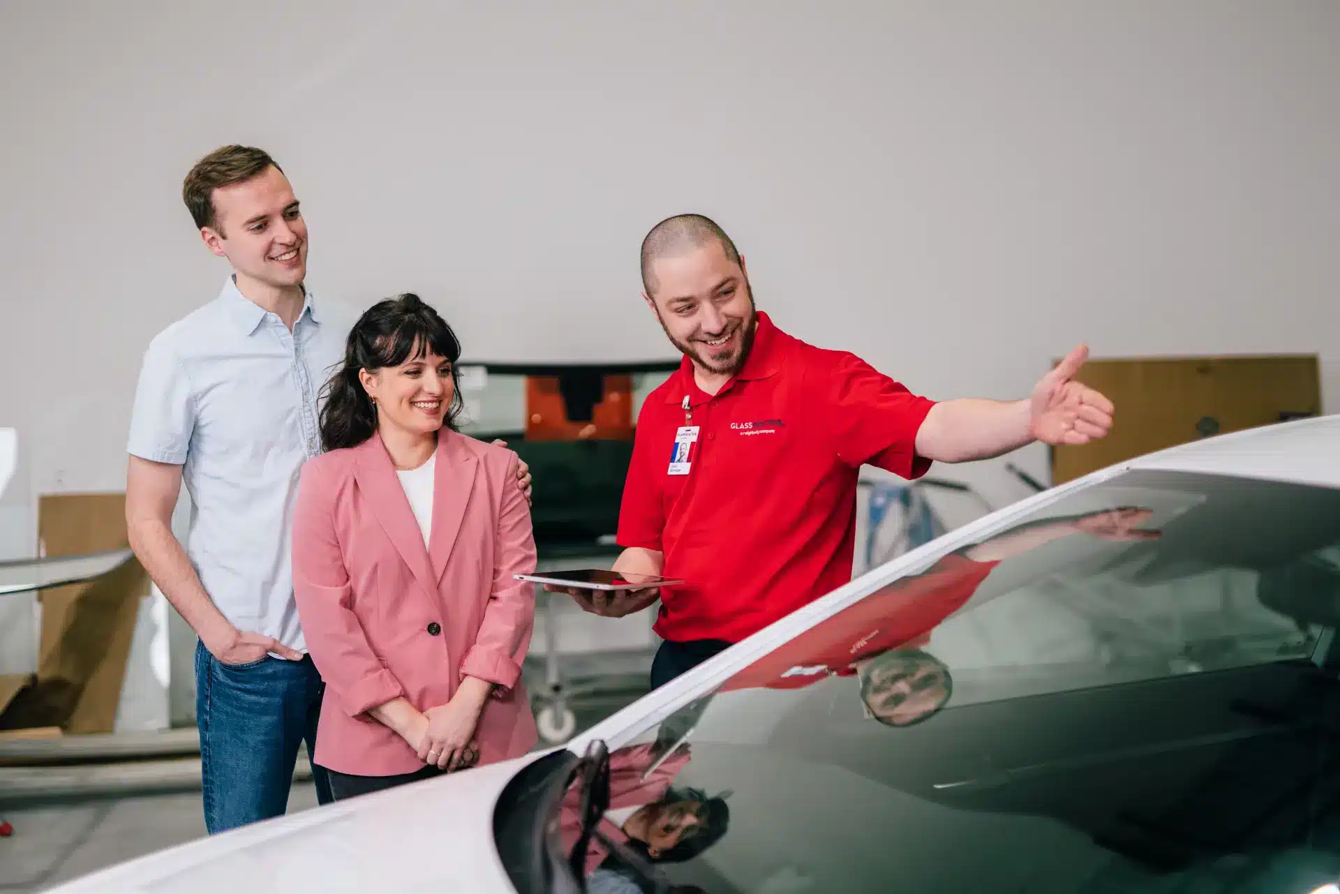 Windshield repair and replacement expert from Glass Doctor showing a couple their completed service in the shop.