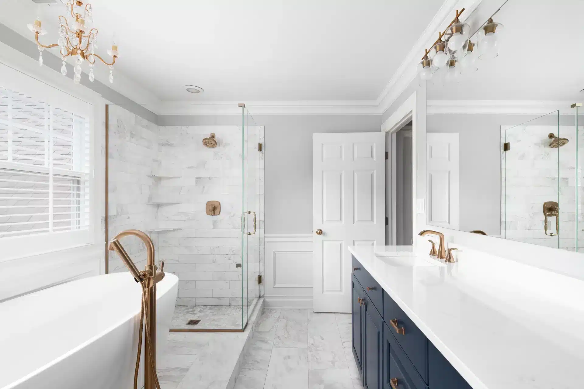 Shower glass repair and replacement featuring a frameless glass shower door in a marble bathroom with brass fixtures.