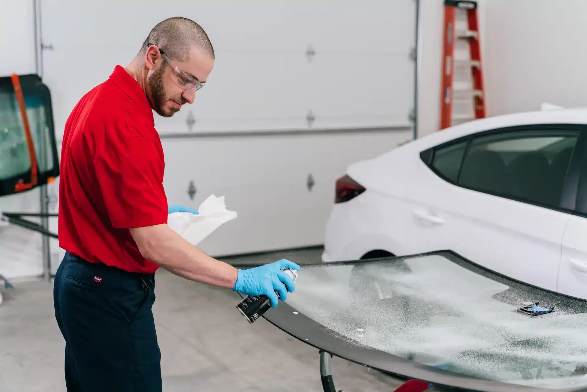 A Glass Doctor technician cleaning and preparing a new windshield during auto glass repair services.