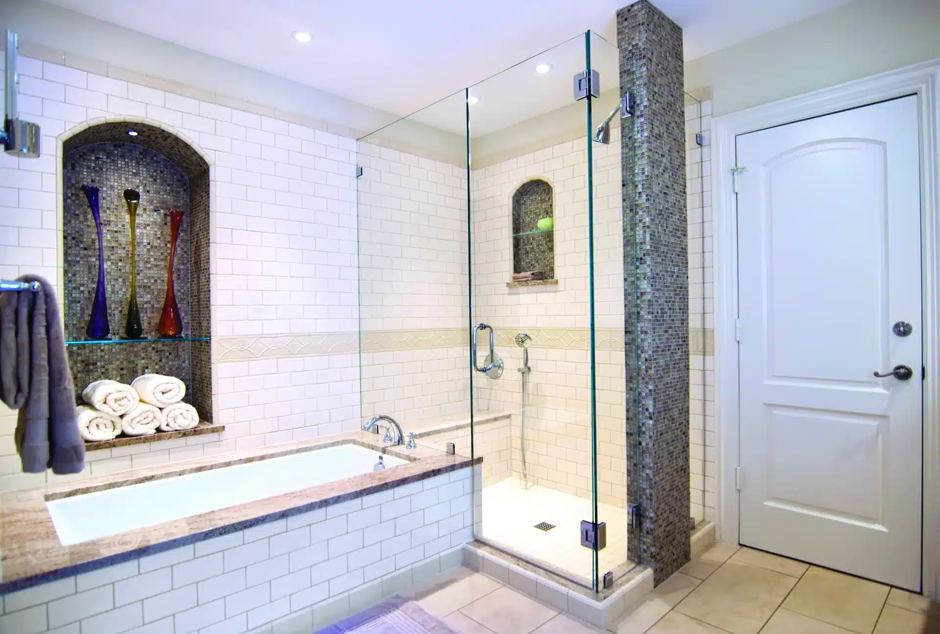 Shower glass repair and replacement in a master bathroom with a frameless glass shower enclosure and subway tile.