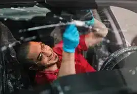 A Glass Doctor technician performing auto glass repair and replacement on a car windshield