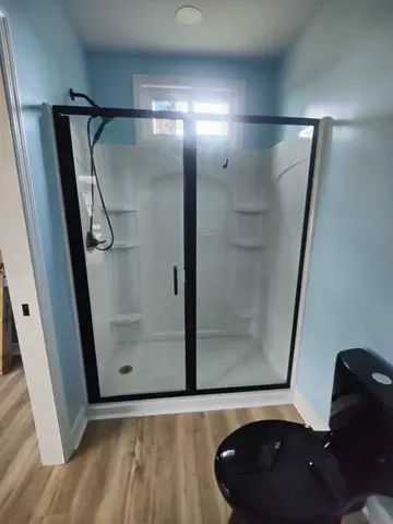 Black-framed glass shower doors with two glass panels on a white vinyl shower by Glass Doctor Home + Business of Myrtle Beach.