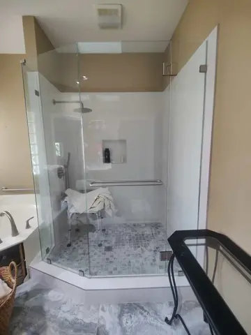 A shower enclosure with frameless clear glass and an angled panel by Glass Doctor Home + Business of Myrtle Beach.