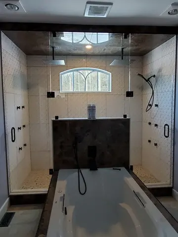 A white tiled shower room with a frameless glass enclosure and jack-and-jill doors on either side and black hardware by Glass Doctor of York Region.