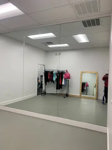Three panels of floor-to-ceiling mirrors filling one wall of a room by Glass Doctor of Nashville.