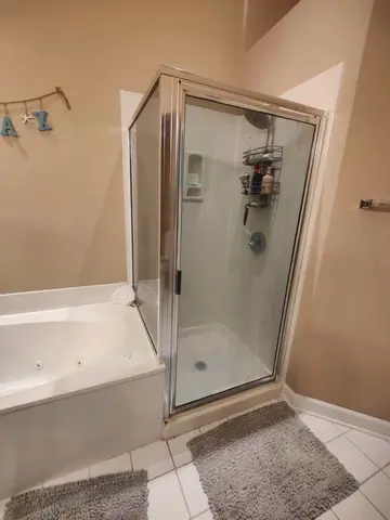 A chrome framed glass shower enclosure next to a tub installed by Glass Doctor Home + Business of Myrtle Beach.