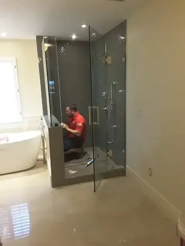 A Glass Doctor of Tampa Bay specialist installing a frameless glass shower enclosure. 