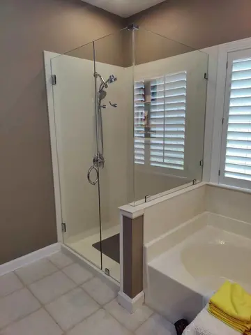 A walk-in shower next to a tub with frameless clear glass enclosure installed by Glass Doctor Home + Business of Myrtle Beach.