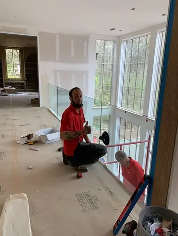 A service professional from Glass Doctor of Nashville installing a glass railing on a walkway.