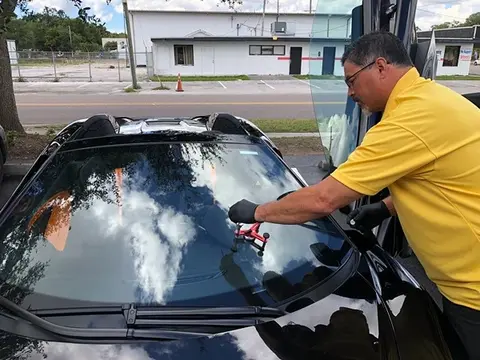 A Glass Doctor of Tampa Bay auto glass specialist performing a rock chip repair on the windshield of a Maclaren.