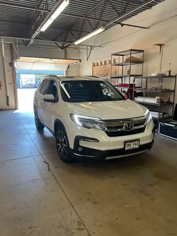 A white SUV sitting in the work bay at Glass Doctor Auto of Castle Rock.