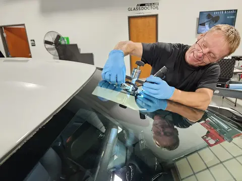 A Glass Doctor Auto of Cedar Park service professional uses to tool in the process of a windshield chip repair job.