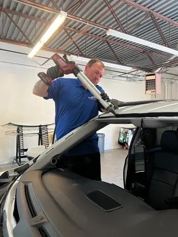 A Glass Doctor Auto of Castle Rock service professional applying sealant for a windshield replacement service.