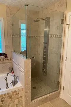 Shower enclosure with full height frameless glass door and frameless glass panels on a half-wall installed by Glass Doctor of Nashville.
