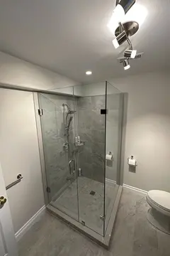 Frameless glass shower enclosure on two sides of a gray tile shower with a 90-degree angle by Glass Doctor of Barrie, ON.