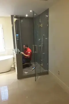 A Glass Doctor of Tampa Bay specialist installing a frameless glass shower enclosure. 