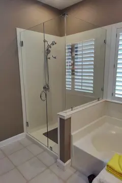 A walk-in shower next to a tub with frameless clear glass enclosure installed by Glass Doctor Home + Business of Myrtle Beach.