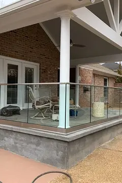 A covered back porch on a house with a custom glass panel railing around it by Glass Doctor of Nashville.