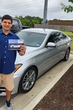 A satisfied customer of Glass Doctor Auto of Cedar Park gives a thumbs up in front of a silver car.