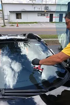 A Glass Doctor of Tampa Bay auto glass specialist performing a rock chip repair on the windshield of a Maclaren.