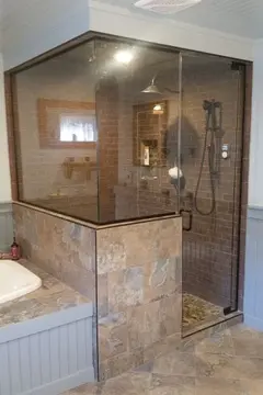 A glass enclosed shower with brown marble tiles on the outside and red brick tiles on the inside.