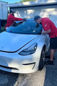Glass Doctor of Tampa Bay auto glass specialists replacing the windshield on a white Tesla.