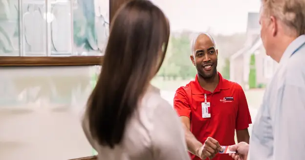A glass doctor technician explaining to a couple.