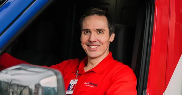 A glass doctor technician in a van.