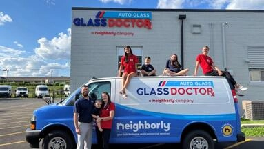 Glass Doctor Auto of Southampton owners Michael and Valerie and their kids with the Glass Doctor van in front of their building.