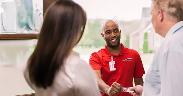 A glass doctor technician explaining to a couple.