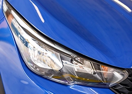 Closeup of headlight of a blue car.