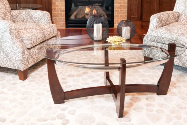 A living room with a glass-top coffee table with wooden legs.