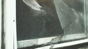 A damaged window with fabric protruding.