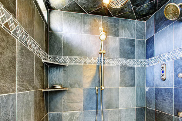 A modern shower featuring a sleek shower head mounted on the wall, with water flowing from it.