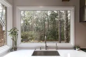 a large window that does not open above a kitchen sink