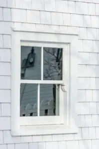 a white singe hung window on the side of a white house