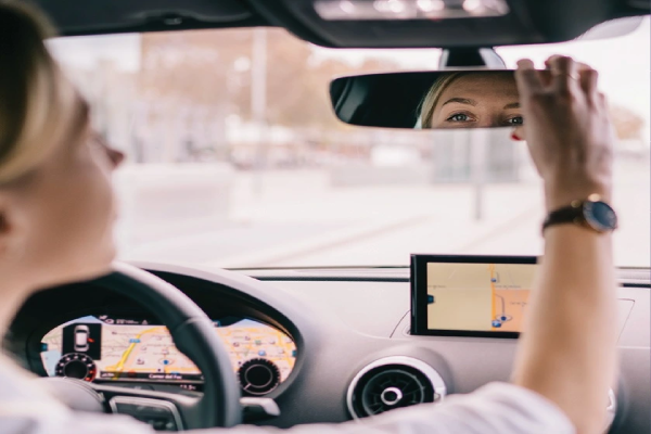A woman examines a map while seated in a car, focused on navigating her route.