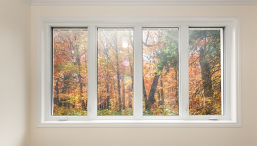 Large four pane window overlooking a colorful fall forest