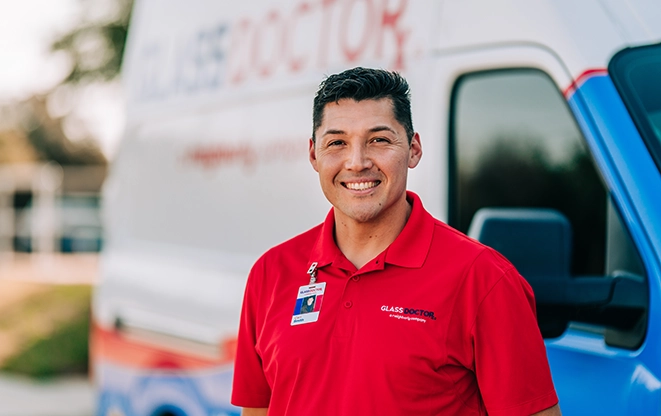 Glass Doctor professional smiling and standing by company van.